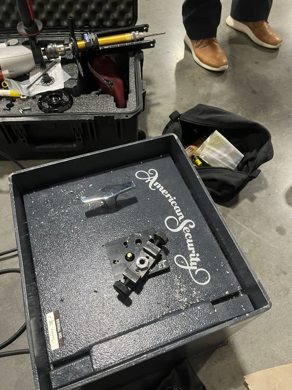 Specialized drilling tools and metal shavings on an American Security safe being professionally opened.